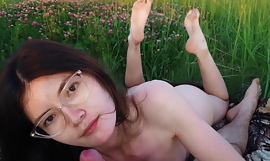 Romantisch afspraak met een meisje bij zonsondergang beëindigd met seks buiten in een open veld tussen bloemen groen