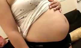 Salope enceinte ventre prêt à papa acquiert sur ses genoux et suce une bite